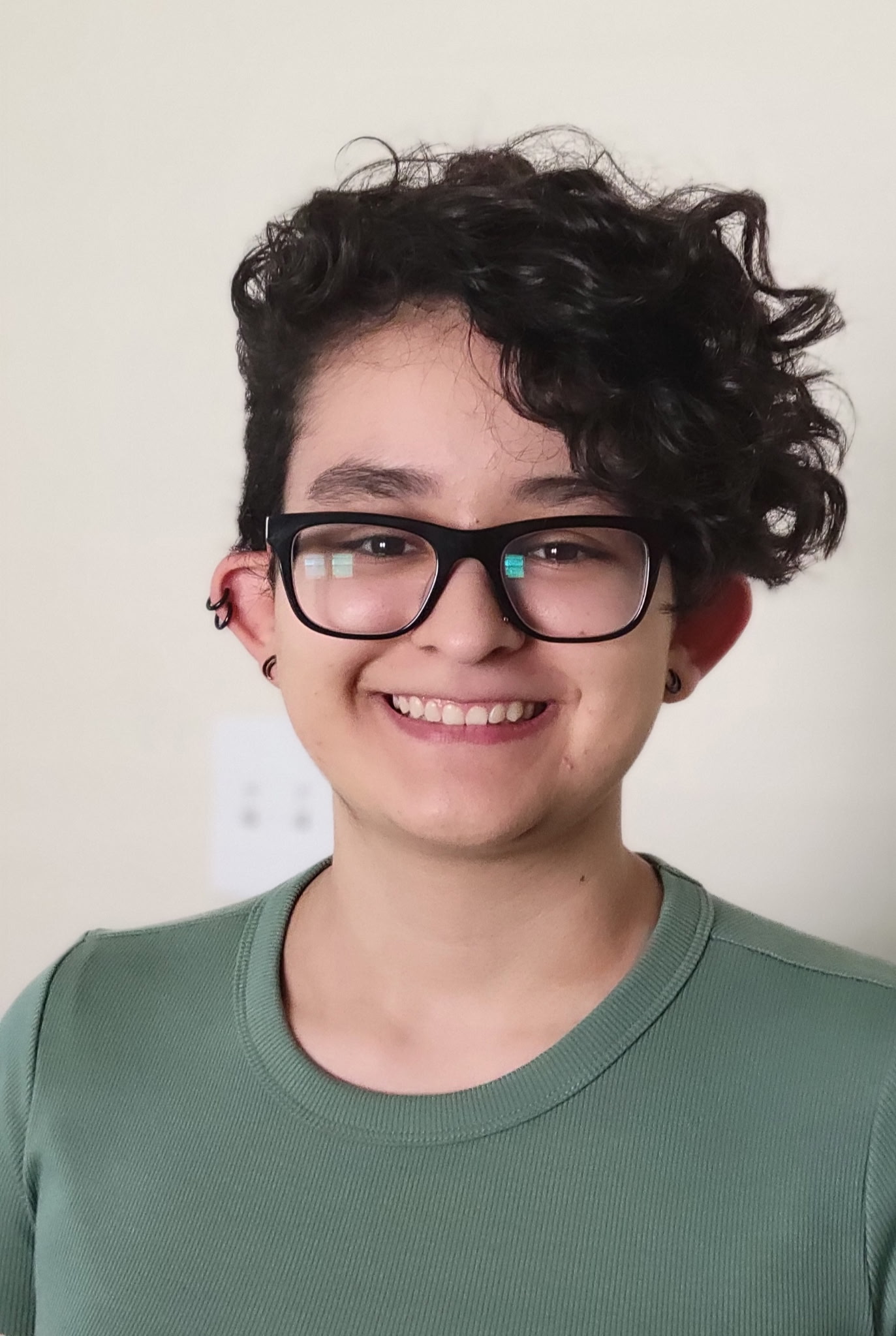 A girl with glasses currly hair and in a green shirt